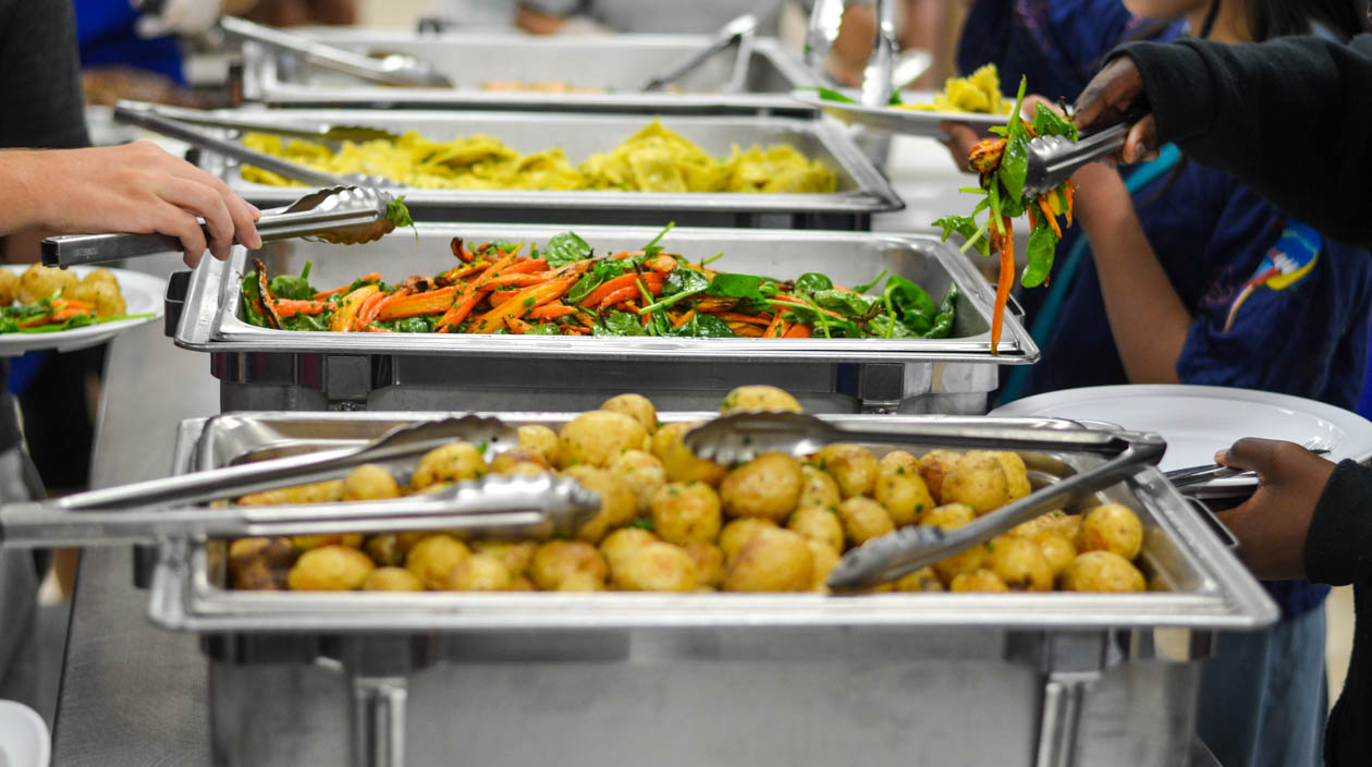 Campers serving themselves from a uffet of food